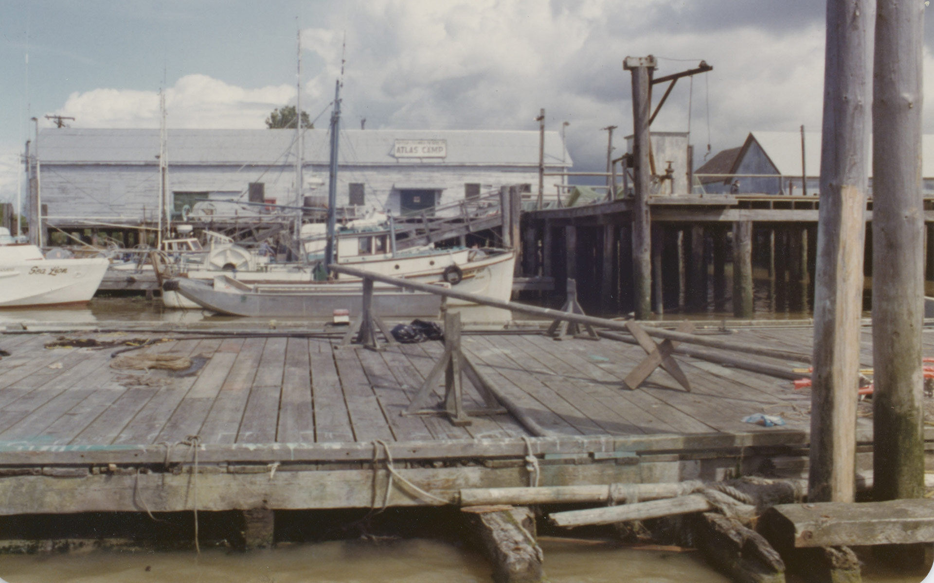 Quais et bateaux de pêche au camp Atlas. Le nom « Atlas Camp » est peint sur le mur latéral du bâtiment à l'arrière-plan.