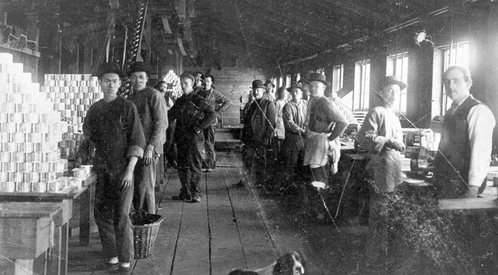 Ouvriers se tenant à leur station de travail dans une conserverie.