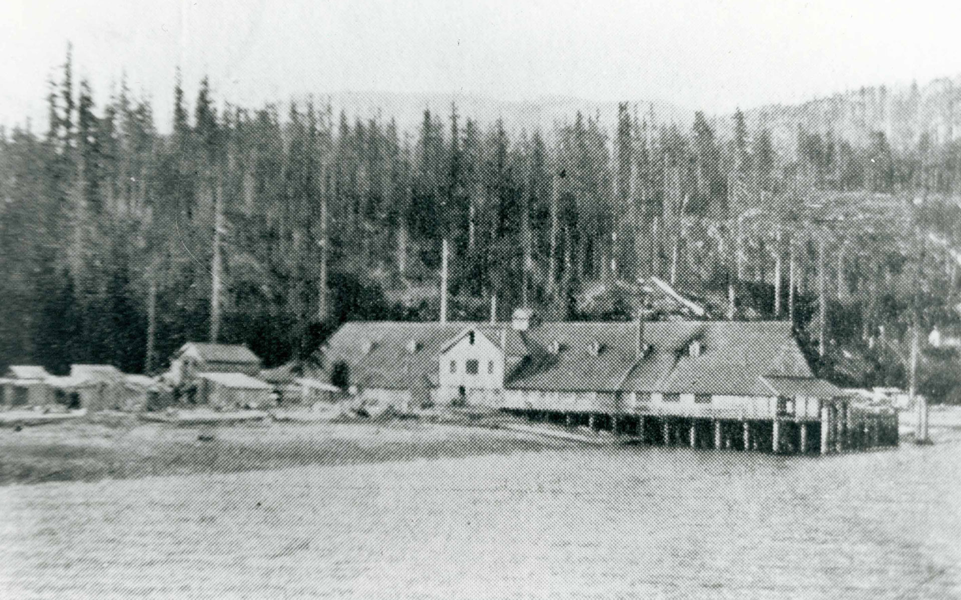 Cannery buildings on the shore viewed from the water.