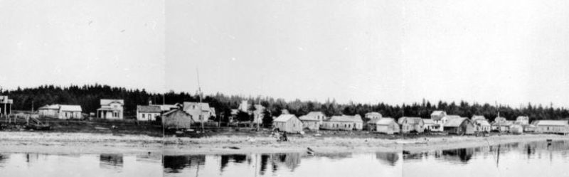 Buildings line the beach facing the water.