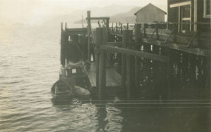 Une section du quai à la conserverie Nootka et un bateau de pêche amarré. Deux skiffs et un bateau de pêche aux filets maillants sont attachés au quai.