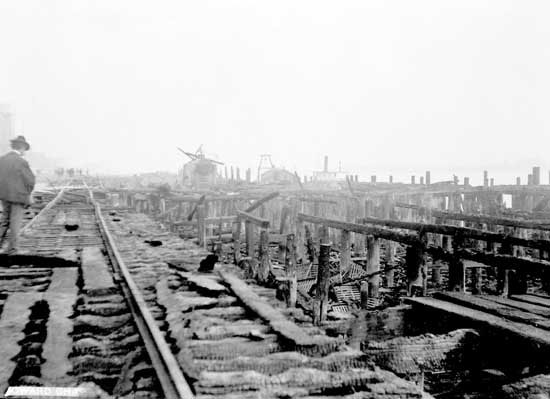 Homme regardant les restes calcinés sur le bord de l'eau à New Westminster.