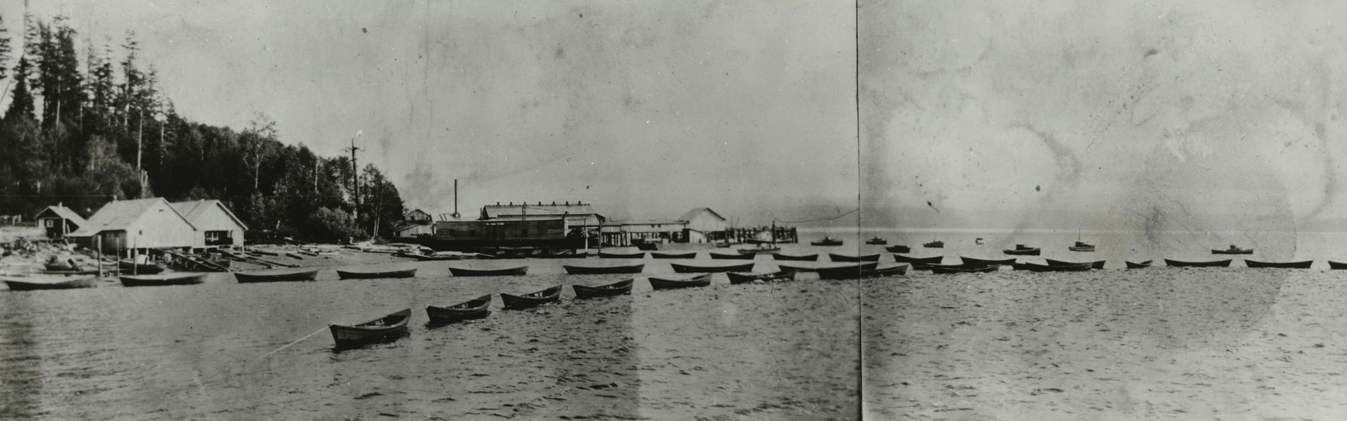 Skiffs de pêche alignés devant les bâtiments de la conserverie.