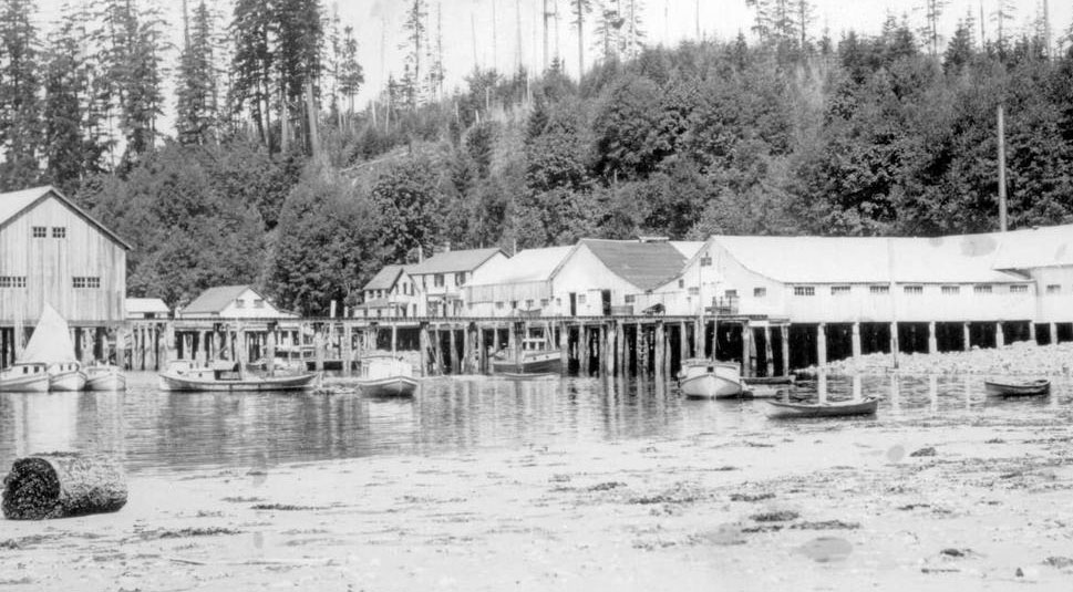 Cannery complex and the pilings beneath the buildings are visible at low tide.