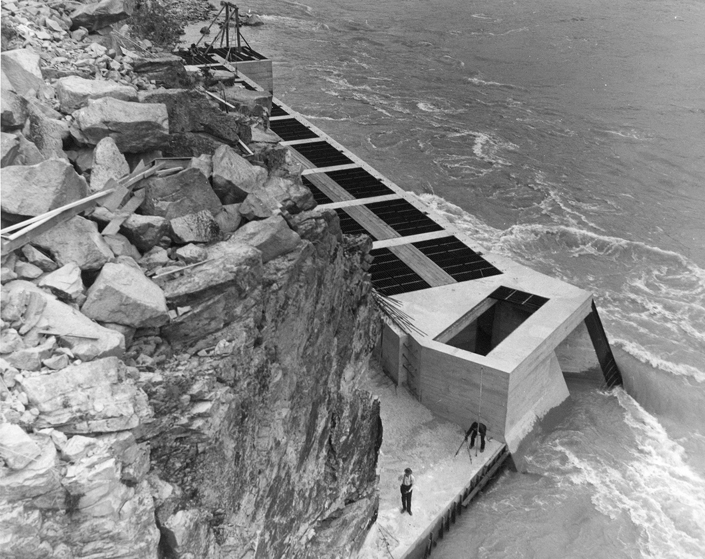 two men with are working on the platform of a fish ladder