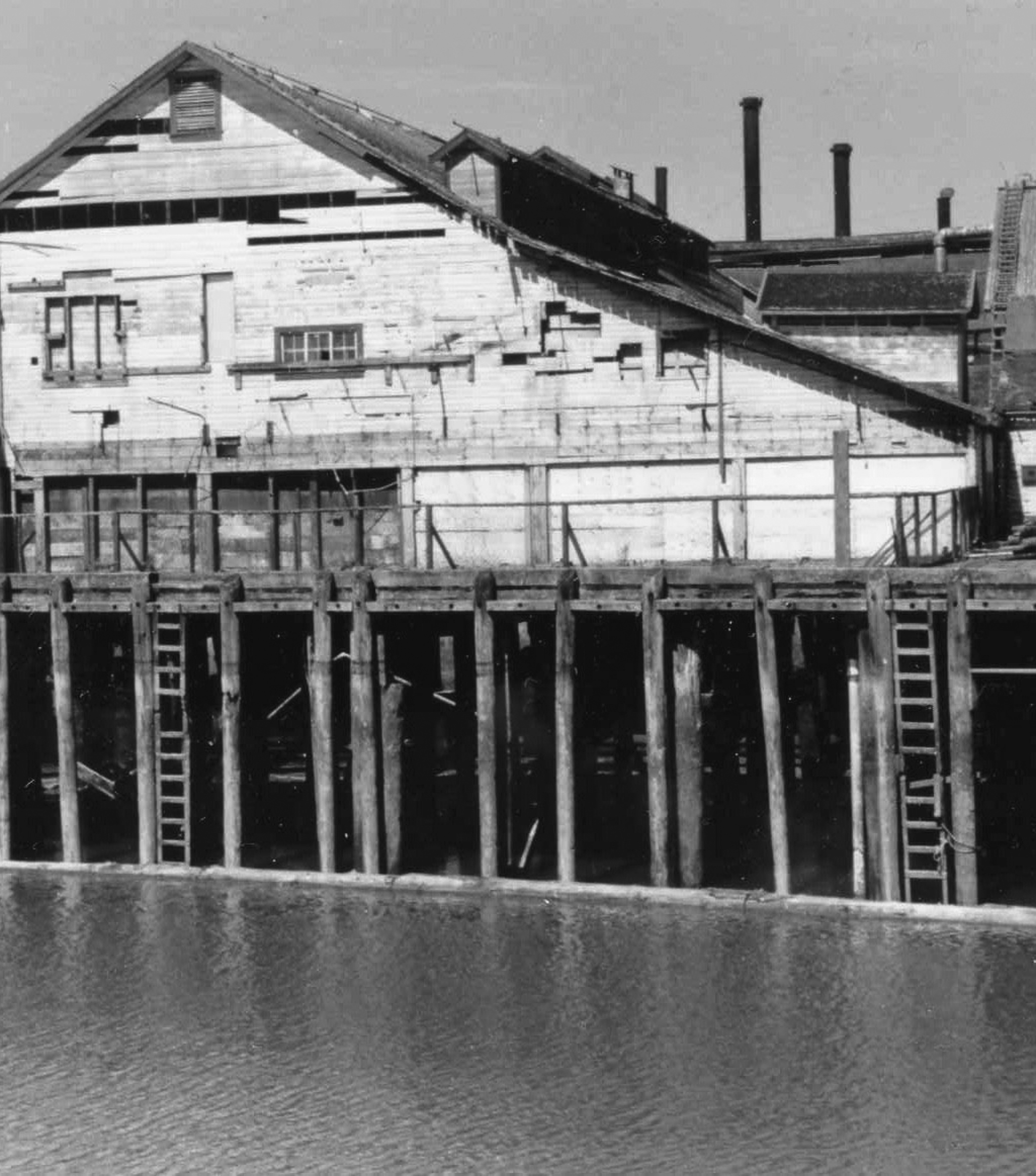 Cannery exterior viewed from the water showing pilings underneath