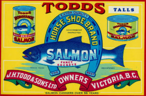 Étiquette de boîte de conserve montrant un saumon au centre d'un fer à cheval renversé.