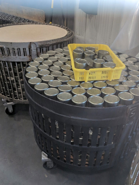 Two metal crates of canned salmon before they are put in the retort for cooking.