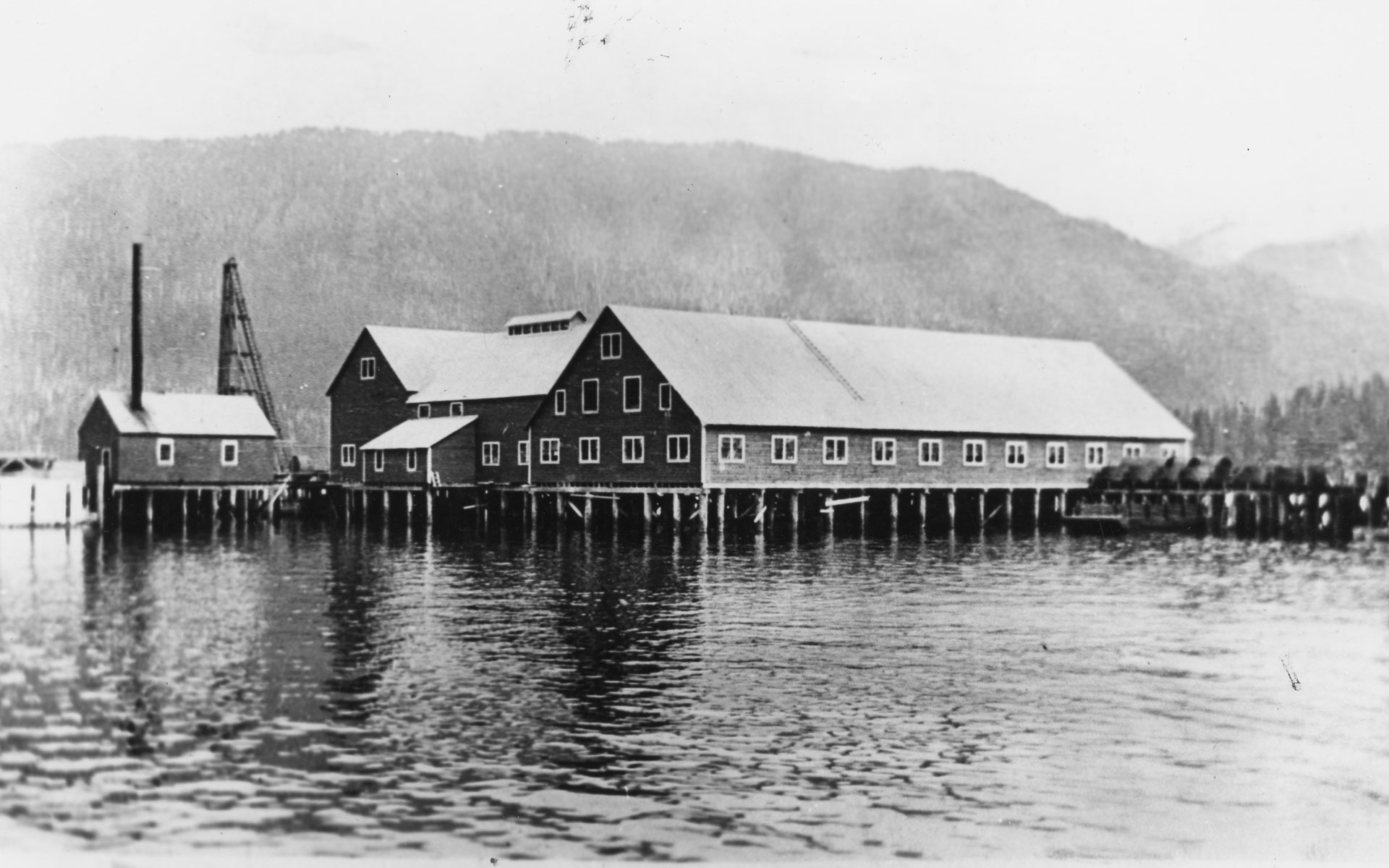 Cannery buildings on pilings over the water.