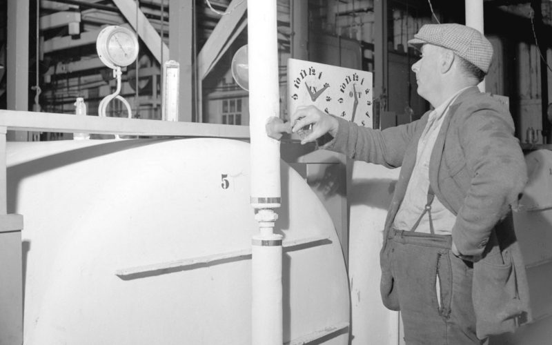 Un homme examine la jauge de température d'un grand four à vapeur.